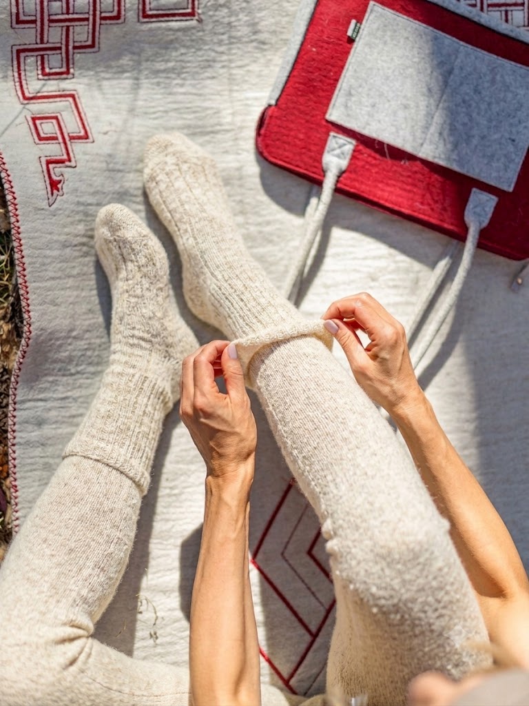 Chaussettes mi-mollet MONLAINE en laine de Mongolie, coloris Écru Naturel, portées en extérieur sur un tapis traditionnel, scène lifestyle.